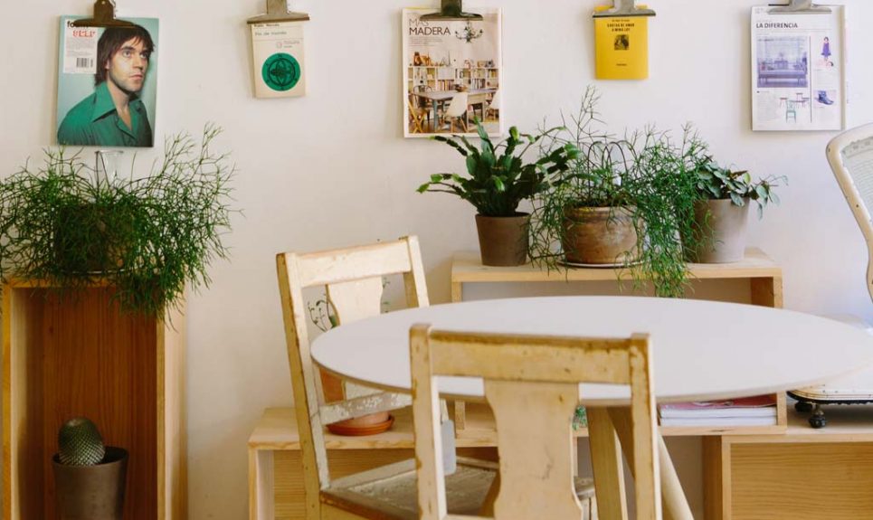 Ein kleiner Raum it Tisch, Sesseln und vielen Bildern an der Wand